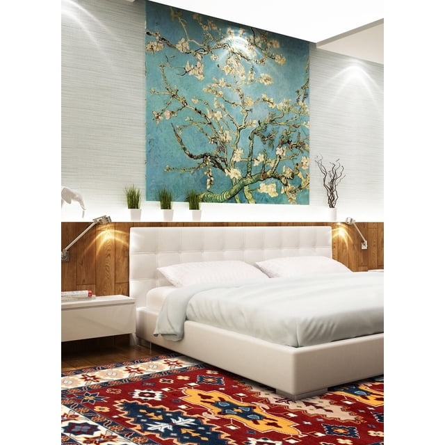 ECARPETGALLERY 100% Wool Traditional Indoor Area Rug featuring bold geometric Kazak patterns in red, yellow, blue, and cream tones on a grey base, displayed in a modern bedroom with a white tufted bed, wooden accent wall, and a large blue floral artwork above the headboard, ideal for entrance, bedroom, living, or dining rooms.