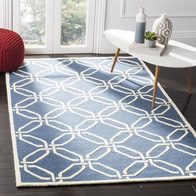 Safavieh Cambridge Kierra Tapis Géométrique Bleu avec Motif Géométrique Chaîne Blanc Cassé, Laine Tuftée à la Main avec Coupe Peluche et Poil en Boucle Haut/bas, Exposé sur Planchers de Bois Franc Sombres dans une Pièce Lumineuse avec une table Basse Blanche de Style Mi-Siècle Moderne Tenant des vases Décoratifs et une Petite Succulente, et un pouf Tricoté Rouge Près de Portes en Verre. le design durable Rug's Convient à la Maison et au Bureau.