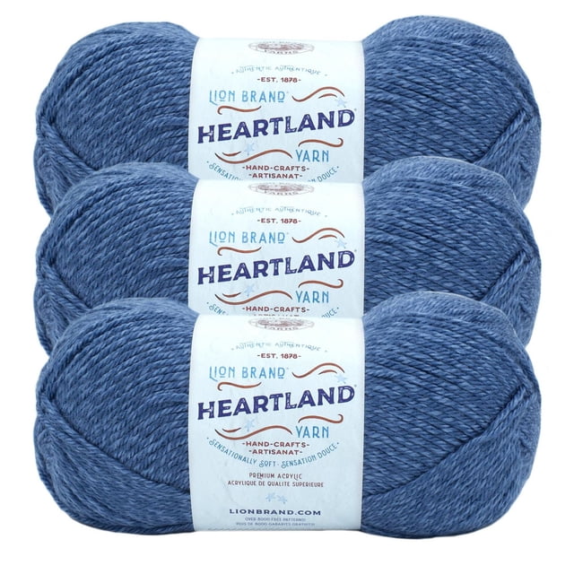 Lion Brand Yarn Heartland Yarn 3Pack featuring three skeins of medium worsted weight acrylic yarn in heathered blue, each with a white label displaying the brand and product name. This machine washable yarn is ideal for knitting, crochet, and durable handmade crafts.