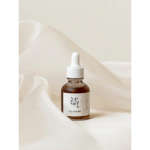 Beauty of Joseon Revive Sérum Serum : Ginseng + Mucine d'Escargot 30 ml dans une Bouteille en Verre Ambré avec Bouchon Compte-Gouttes Blanc et Étiquette Texte Coréenne, Repose sur un Tissu beige Doux, Mettant en Valeur Ses Propriétés Hydratantes facial avec des Ingrédients Traditionnels d'Herbes Coréennes pour Nourrir la Peau.