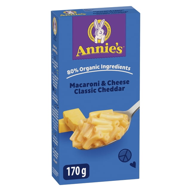 Annie's Macaroni & Cheese Classic Cheddar kid meals 170 g box with blue packaging featuring the Annie's logo with a white rabbit on purple, text stating 80% organic ingredients, and a spoonful of creamy macaroni and cheese with cheddar blocks behind it, ideal as a quick pasta side dish.