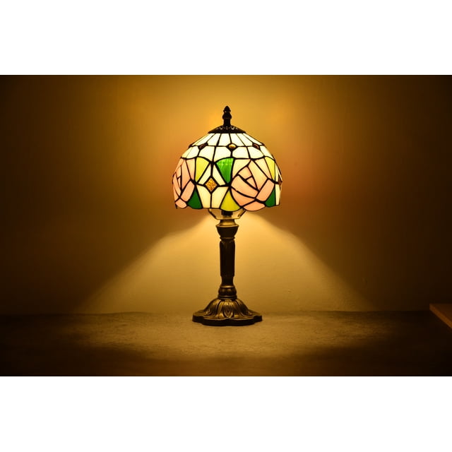 Tiffany Style Lamp Table Desk Lamp Rose Bedroom Bronze Stained-Glass 14.5'' Height Multi-Color. This handcrafted table lamp features a multi-color stained-glass shade with a rose design, supported by a bronze resin base. Measuring 7.5 x 7.5 x 14.6 inches and weighing 4.3 lbs, it is ideal for bedroom nightstands or living room decor. The lamp requires one E26 bulb (not included) and includes a 75-inch cable for convenient placement.
