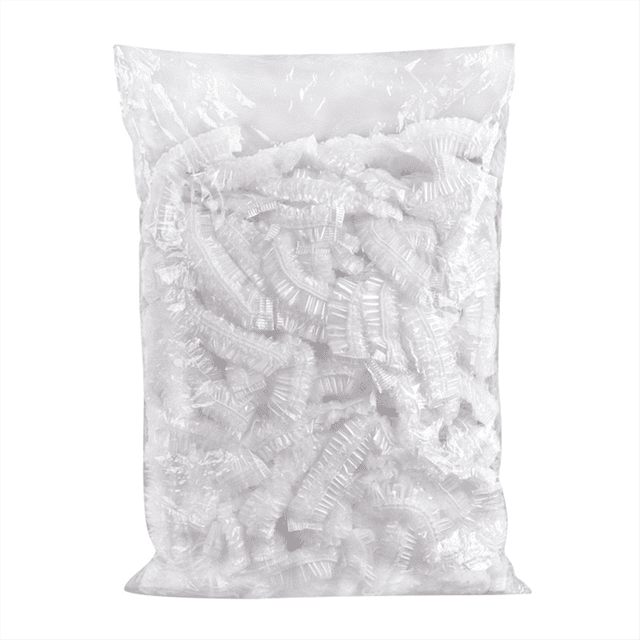 A clear plastic bag containing 100 disposable shower caps. These transparent, elastic, waterproof caps are designed to protect hair during bathing, hair treatments, or conditioning. Suitable for all head sizes, they are multipurpose and can also be used to cover bowls in the kitchen. Ideal for home, hotel, spa, or travel use.