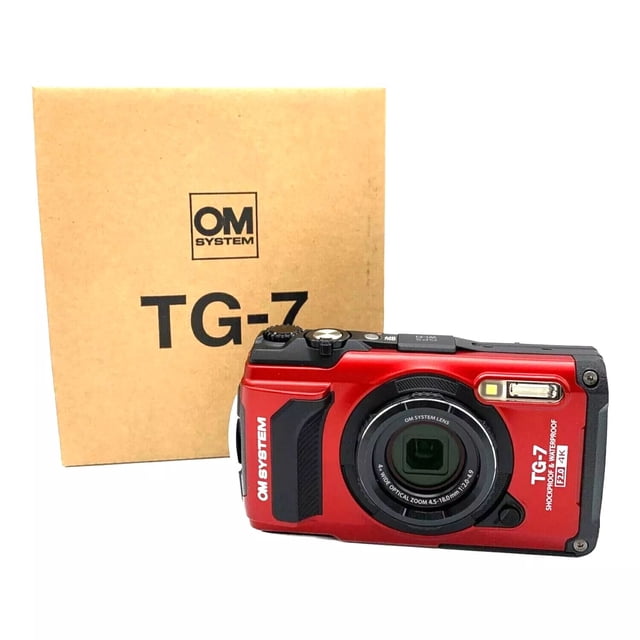 Olympus OM SYSTEM Tough TG-7 Digital Camera in red, a durable point-and-shoot camera designed for outdoor use. Features include a 12MP BSI CMOS sensor, TruePic VIII image processor, wide f/2 aperture, and ISO up to 12,800 for superior low-light performance. Displayed with its branded packaging, the camera supports vertical video, interval shooting, exposure smoothing, and USB-C connectivity. Compatible with 17 accessories, including fisheye converters and underwater housings.