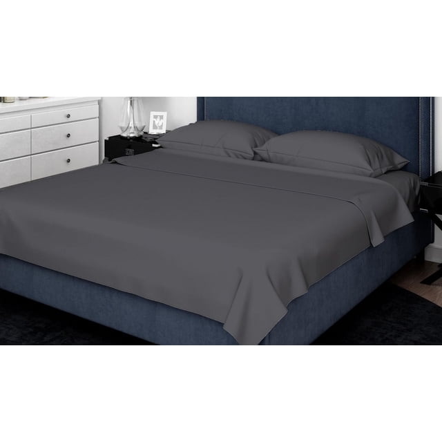 Johnson Home 600 TC Bed Sheet Set - Woven Cotton Sheets in dark grey, laid on a navy blue upholstered bed with a tall headboard and silver nailhead trim, featuring breathable, durable woven fabric and matching pillowcases, in a modern bedroom with white dresser and black nightstand.