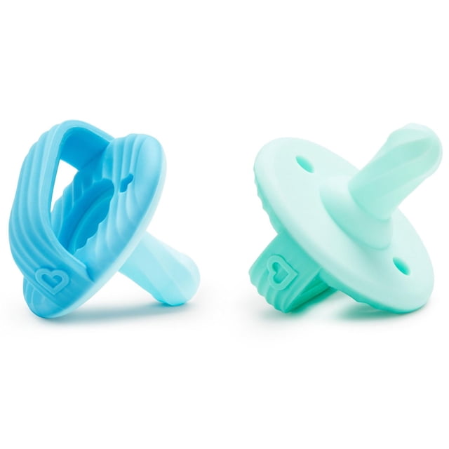 Munchkin Sili-Soothe & Teethe ™ Silicone Pacifier & Teether, 2 Pack featuring two pastel silicone pacifiers in light blue and mint green with multi-textured ridged surfaces for teething relief, made from durable 100% food grade silicone, lightweight one-piece design safe for babies 3+ months, each with a heart detail on the handle.