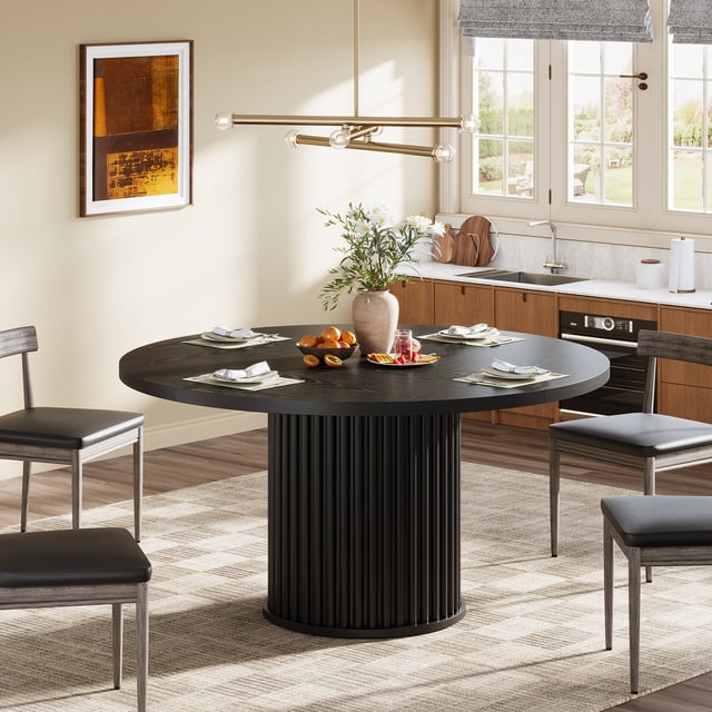Table à Manger Ronde pour 4 à 6 Personnes, Table de Cuisine Ronde de 47,24 Po avec Base Métallique Cannelée Robuste, Noire. Cette Table à Manger Moderne Présente un Plateau en MDF Noir Texturé et une Base Piédestal en Métal Cannelée, Mêlant style et Fonctionnalité. Idéale pour les Salles à Manger Ou les Cuisines, Elle Peut Accueillir jusqu'à 6 Personnes Confortablement. la Table Est Conçue avec de la Vaisselle et un vase Décoratif dans un Décor de Cuisine Contemporain et Lumineux.