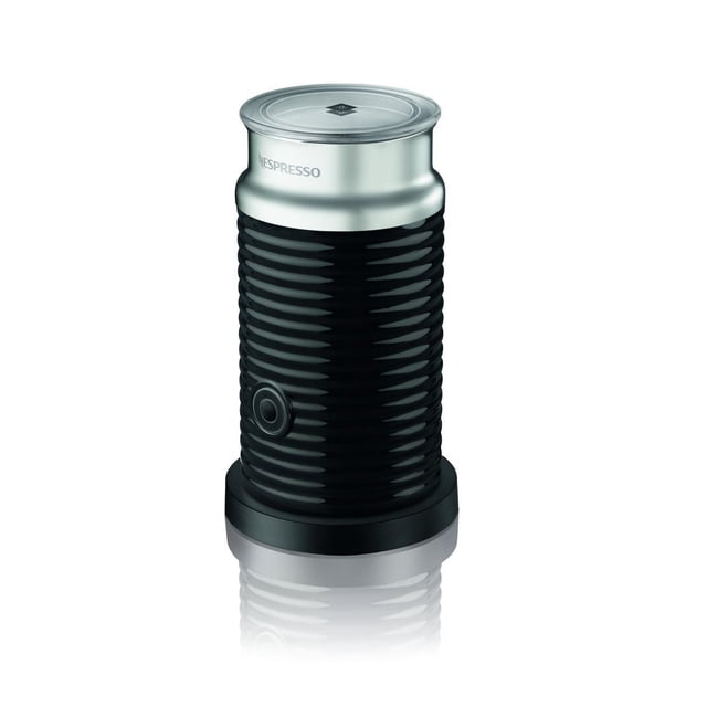 Nespresso® Aeroccino 3 Milk Frother in black with ribbed cylindrical body and silver metallic top featuring the Nespresso logo, front-facing on white background, with one button for easy operation to make hot or cold milk froth for coffee.