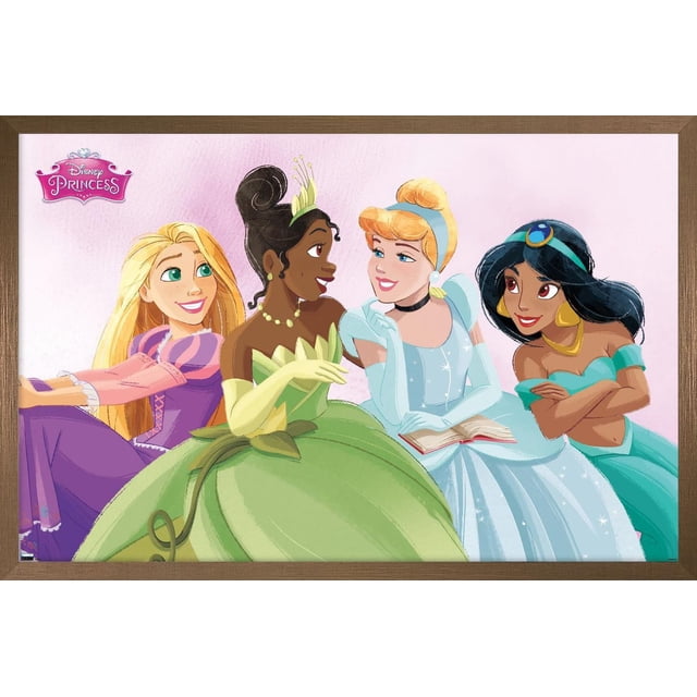 Disney Ultimate Princess Celebration - Group Wall Poster, 22.375" x 34" framed showing four Disney princesses in colorful detailed gowns: purple, green ball gown with gloves and pearl necklace, light blue sparkling dress with gloves holding an open book, and turquoise outfit with gold jewelry, on a pale pink background within a brown wooden frame, suitable for bedroom or kid's room wall decor.