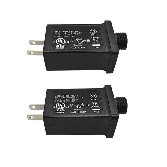 Two black 12V 1A Class 2 Power Supply units designed as LED transformer replacements for string lights and inflatable devices. Each unit features a rainproof IP44 rating for indoor and outdoor use, with input specifications of 100-240V, 50/60Hz, and output of 12V, 1000mA. The compact design includes UL and CE certifications, making it suitable for low-voltage LED devices such as holiday decorations, Christmas trees, and lawn lamps.