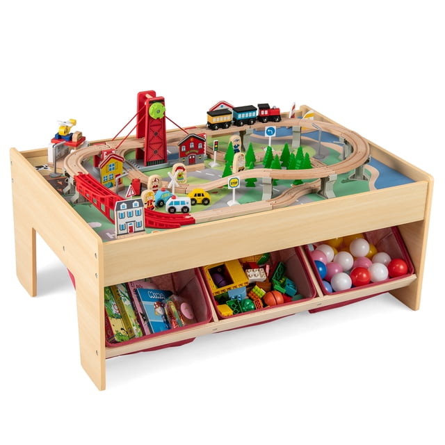 Gymax 94 PCS Wooden Train Set Table with reversible tabletops, 3 collapsible storage bins, and a 94-piece train set including tracks, cars, buildings, figures, and a pulley drawbridge. Made of solid wood and MDF, this activity play table fosters creativity and storytelling for children aged 3 and up.