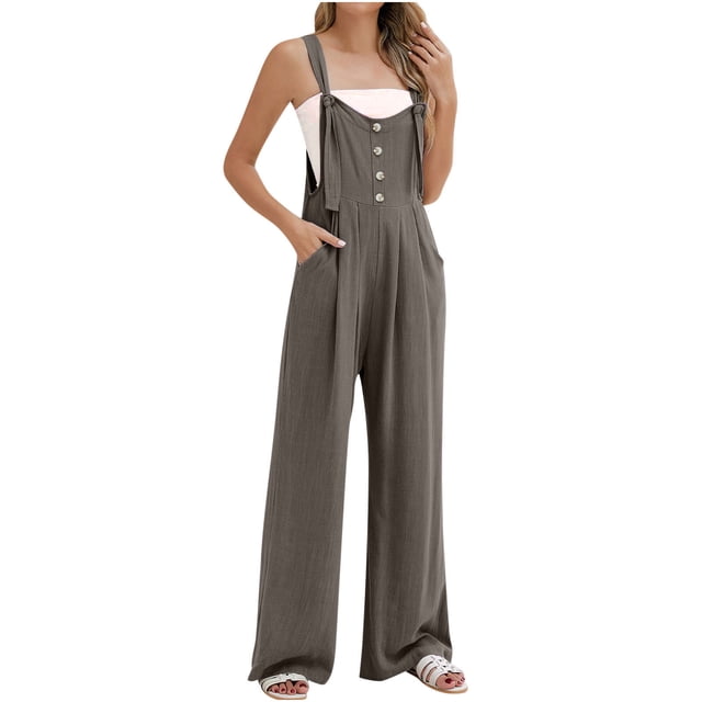 AherBiu Summer Jumpsuits for Women featuring a sleeveless design with button suspenders, straight-leg cut, and pockets. Made from soft polyester fabric, this boho-style romper is shown in a neutral tone. The model pairs it with a white bandeau top and sandals, highlighting its casual and versatile appeal.