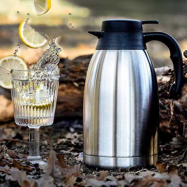 Cresimo Carafe à Café Thermique en Acier Inoxydable de 2 Litres avec Conception à Isolation sous Vide à Double Paroi, Présentée à l'Extérieur dans un Cadre Naturel avec des Feuilles Tombées. la Carafe Présente un Corps Élégant en Acier Inoxydable avec une Poignée et un Couvercle Noirs, Conçu pour Garder les Boissons Chaudes pendant 12 Heures Ou Froides pendant 24 Heures. un Verre d'Eau Glacée au Citron Est Placé à Côté de la Carafe, Soulignant Sa Polyvalence pour les Boissons Chaudes et Froides.