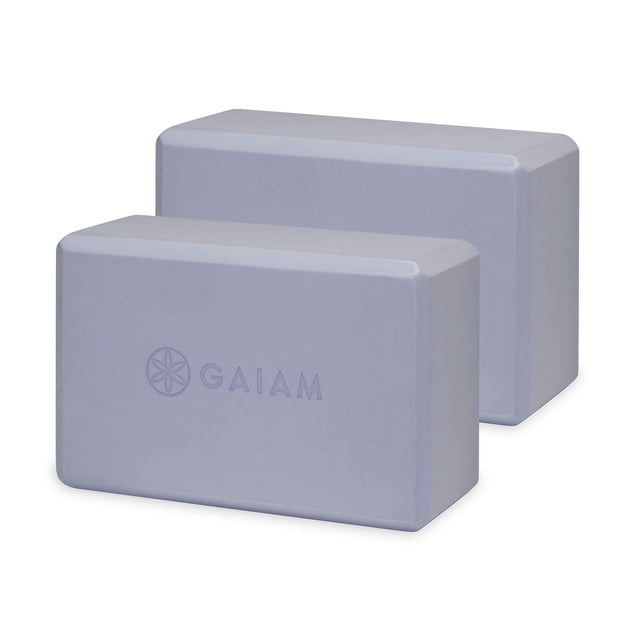 Gaiam Yoga Block Wild Lilac- 2 Pack with two lightweight rectangular blocks in a muted lilac color featuring the Gaiam logo, designed to support and deepen stretches, improve balance, and assist alignment with a non-slip surface, also suitable as a gentle prop for seated stretches.