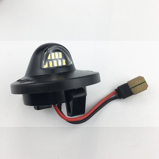 Lampe à Plaque d'Immatriculation PC à DEL pour Ford F150 F250 F350, Dotée d'Un Boîtier compact Noir avec un Objectif Transparent Mettant en Valeur Plusieurs Ampoules à DEL. Conçue pour les Systèmes 12 V avec une Puissance de Sortie de 3 W et une Température de Couleur de 6500 K. Comprend un Faisceau de Câblage Rouge et Noir avec un Connecteur Doré. Compatible avec Divers Modèles Ford, Y Compris F-150, F-250, F-350 et Autres. Vendue par Paire