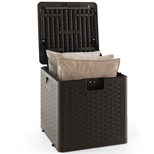 Costway Coffre de Terrasse de 28 Gallons en Brun avec surface imitation Rotin, Montré avec Couvercle Ouvert et Coussins Beiges Rangés à l'Intérieur. Fabriqué en Matériau HDPE Résistant aux Intempéries, Ce Contenant de Rangement Imperméable Convient aux Outils, Jouets et Accessoires de Terrasse. Il Présente un Couvercle Verrouillable, des Poignées Intégrées pour la Portabilité et une Conception Robuste Qui Fait Aussi Office de table d'Appoint Ou de Siège. Idéal pour les Espaces Extérieurs comme les patios, les Jardins et les Zones au Bord de la Piscine.