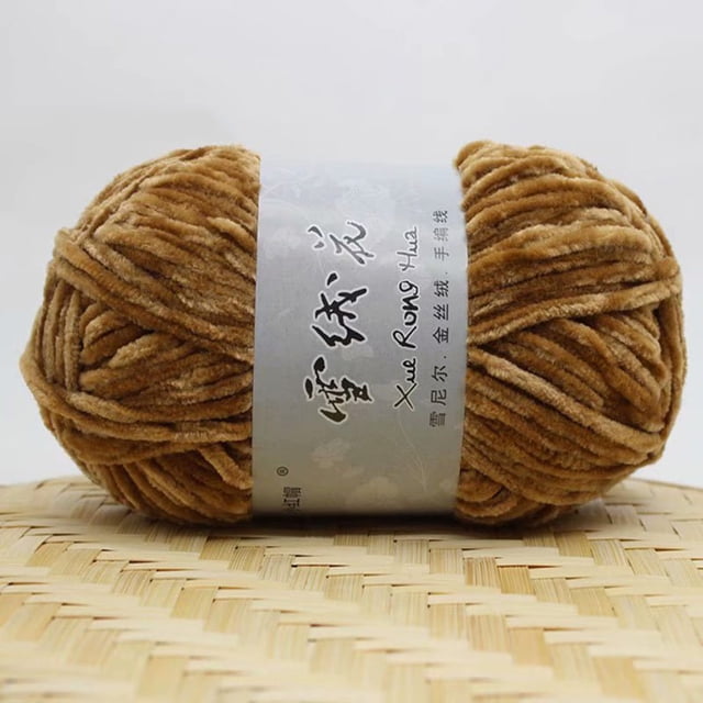 Kcavykas Gold Velvet Chenille Medium Thick Wool Yarn, 180m. A 100g skein of soft, gold-colored chenille yarn with a 5mm thickness, ideal for DIY crochet projects like scarves, hats, and gloves. The yarn is displayed on a woven surface with a branded label featuring decorative text.