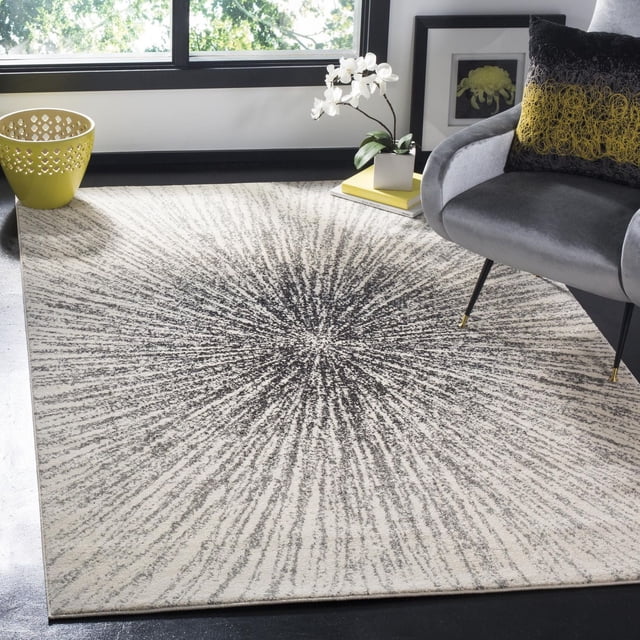 Safavieh Evoke Vana Abstract Geometric Area Rug 5'1" x 7'6" in black and ivory with a radial burst pattern and power-loomed polypropylene frieze texture, displayed in a modern room with a gray armchair, black and yellow pillow, yellow basket, and white orchid near a window, suitable for accenting living spaces.