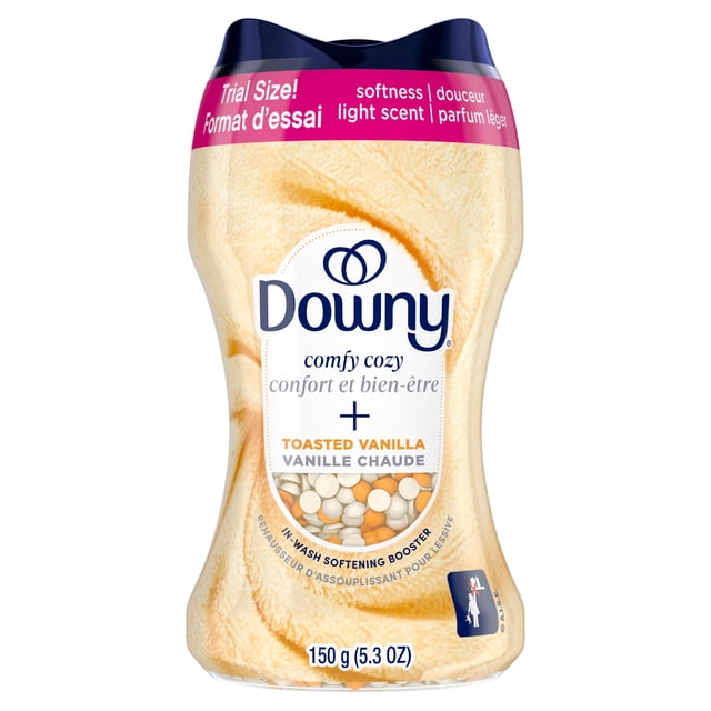 Downy Comfy Cozy In-Wash Laundry Scent Booster Beads in toasted vanilla scent, trial size 150 g (5.3 oz) container with soft beige fabric texture background and visible white and orange scent and softening beads, ideal for adding softness and a light scent to laundry loads.