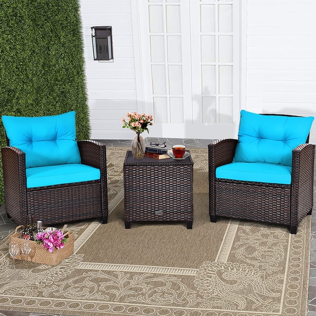 Costway Ensemble de Mobilier de Terrasse en Rotin 3 Pcs, Ensemble de Conversation Rembourré avec Canapé turquoise, Comprenant Deux Chaises Simples en Rotin avec Coussins turquoise et une table Basse Carrée avec Dessus en Verre Trempé. l'Ensemble Est Exposé sur un Tapis Extérieur beige dans un Décor de Patio avec un Mur Blanc et de la Verdure en Arrière-Plan. le Rotin Est un Mélange de Tons Bruns, et les Coussins Sont Épais et Doux pour un Confort Accru. Idéal pour les Espaces Extérieurs comme les patios, les Jardins Ou les Zones au Bord de la Piscine.