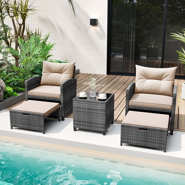 Costway 5 PCS Patio Rattan Furniture with 2 Ottomans & Tempered Glass Coffee Table in beige, featuring mix gray PE rattan construction. The set includes two chairs with ergonomic backrests and curved armrests, two versatile ottomans that can serve as footrests, extra seats, or side tables, and a square coffee table with a tempered glass top secured by suction cups. Cushions with soft fillings and removable covers provide added comfort. Ideal for outdoor spaces like patios, poolside, or balconies.