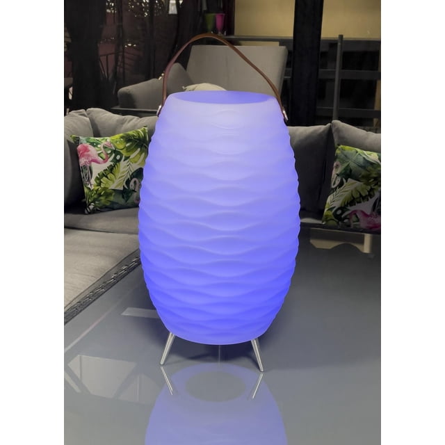 Dura Seau à Glace à DEL Vegas Bleu Lumineux avec une surface Texturée et Ondulée, Posé sur Trois Pieds en Métal Argenté sur une table en Verre Réfléchissante dans un Salon avec Canapés Gris et Coussins Tropicaux, Convient aux Fêtes et aux barbecues.