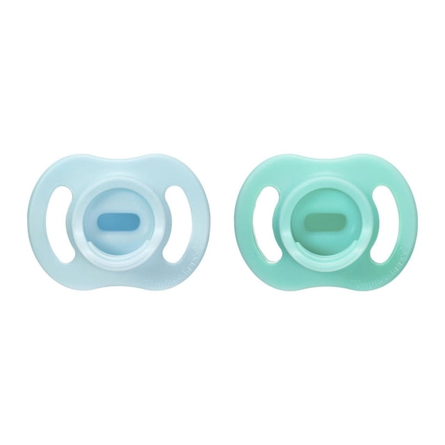 Tommee Tippee Ultra-light StayPut Pacifier 2 pack with one-piece silicone design in light blue and mint green, symmetrical nipple and shield with air flow openings, lightweight and designed to stay put for babies 0-6 months.