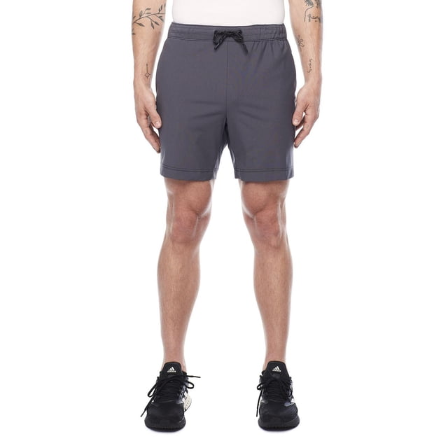 Jogger Technologique de Confort Noir Foncé en Gris, Vue avant sur un Modèle Masculin. Ces joggers de performance pour Hommes en polyester avec Taille Élastique jacquard et Cordon de Serrage pour un Confort Toute la Journée, Idéal pour le gym, les sports de Plein Air, les Loisirs Ou les Voyages.