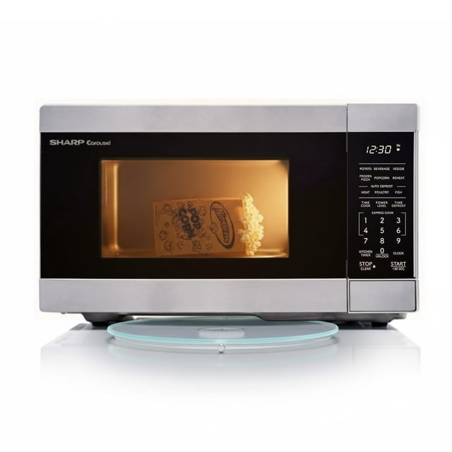 SHARP SMC0962KSC Compact Countertop Microwave Oven with 0.9 cu. ft. capacity and 900W power. Features a stainless steel finish, one-touch cooking buttons for popcorn, potatoes, frozen pizza, and more, as well as an auto defrost function for meats and fish. Includes a 10.6-inch removable glass turntable for even heating. The control panel displays preset options and a digital clock. Shown with a bag of popcorn inside, illuminated by the interior light.