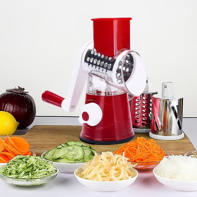 Rotary Cheese Grater, 3 In 1 Kitchen Shredder Vegetable Slicers with 3 Interchangeable Blades in red, displayed on a countertop. The grater features a hand-crank handle, a transparent drum, and a suction base for stability. Three stainless steel drum blades are shown alongside, suitable for fine grating, coarse shredding, and slicing. Surrounding the grater are bowls of sliced and shredded vegetables, including cucumbers, carrots, and onions, showcasing its versatility for food preparation.