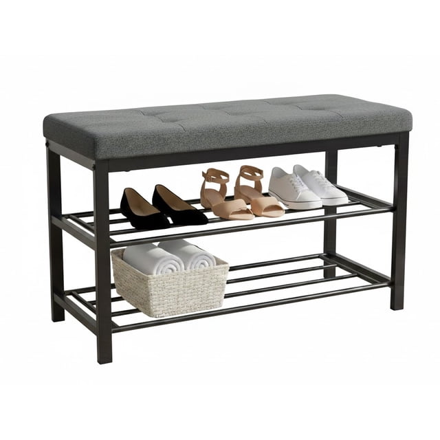 Nola Home 2-Tier Shoe Rack Bench with Padded Seat in grey, featuring a black metal frame and soft fabric upholstery. The bench includes two open metal shelves that hold up to 6 pairs of shoes, with a compact design ideal for entryways, hallways, or mudrooms. The sturdy frame supports up to 200 lbs and includes non-slip foot caps for floor protection. The top cushion provides a comfortable seating area for putting on or removing shoes.