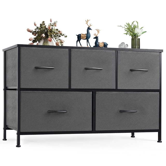 EDX Commode à 5 Tiroirs pour Chambre, un Organisateur de Rangement en Tissu Gris avec un Cadre en Acier Robuste et un Dessus en Bois. la Commode Présente Cinq Tiroirs Spacieux avec des Poignées Épurées, Offrant un Grand Rangement pour Vêtements et Accessoires Tout en Préservant l'Intimité. des Patins de Pieds Ajustables Assurent la Stabilité sur les Planchers Irréguliers. le design Moderne Complète Divers styles de Déco pour Chambre Ou Salon. Convient comme Meuble Télé compact, avec des Articles Décoratifs comme des vases et des figurines Exposés sur le Dessus en Bois.