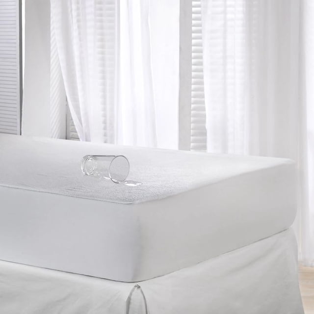 Protège-matelas en Ratine Imperméable Très Grand Montré sur un Lit avec un Verre d'Eau Déversé à Sa surface, Démontrant Ses Propriétés Anti-Liquides. Fait de 80 % Coton et 20 % Tissu en Ratine de polyester avec un envers 100 % Polyuréthane et un Jupon 100 % polyester. Conçu pour s'Adapter aux Matelas jusqu'à 12 Pouces d'Épaisseur, Il Présente une membrane Respirante pour la circulation de l'Air et le Confort. le Tissu en Ratine Doux Ajoute une Couche Supplémentaire de Confort Tout en Protégeant