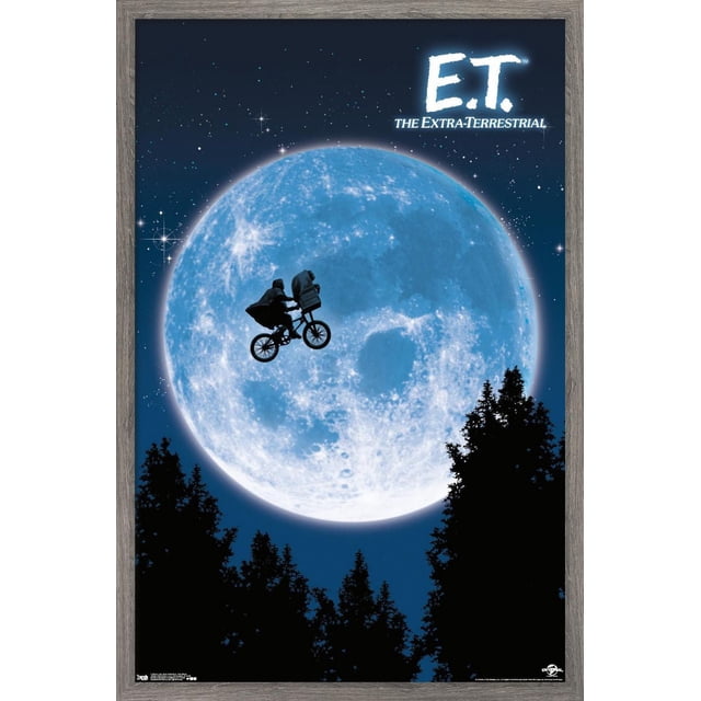 E.T. The Extra-Terrestrial Wall Poster, 22.375" x 34", depicting a silhouette of a boy riding a bicycle with an alien in the basket flying across a large blue moon against a starry night sky framed by dark tree silhouettes, printed on glossy poster paper suitable for bedroom or office wall décor.