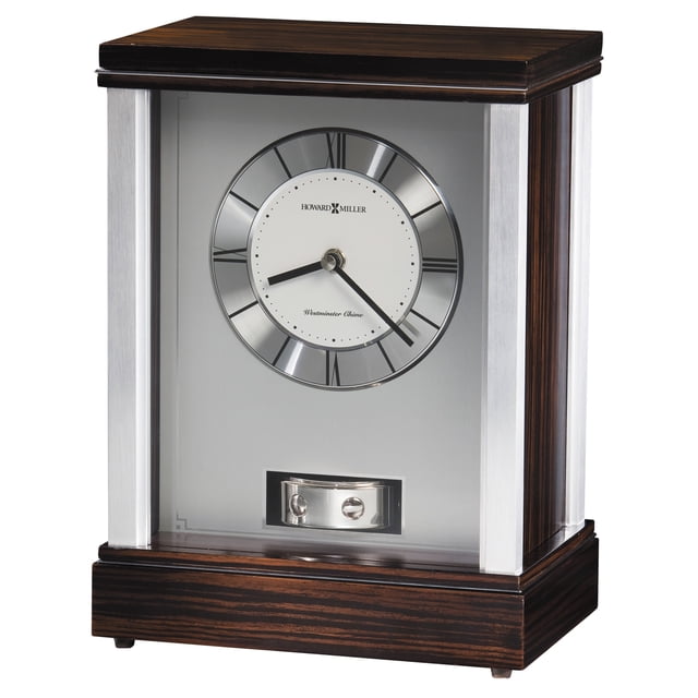 HOWARD MILLER GARNNER MANTEL CLOCK 635172 Conçu pour la Déco de la Maison, avec Coins en Aluminium Brossé, accents Ton Argent Poli, et un Dessus et une base Finis en Faux Ébène Macassar. Cette MANTEL CLOCK Comprend une Bague Chiffre Circulaire en Aluminium avec Chiffres Romains Noirs, un Centre Argent Satiné et un Pendule Tournant. Alimenté par un Mouvement à quartz avec Fonctionnalité Carillon Westminster.