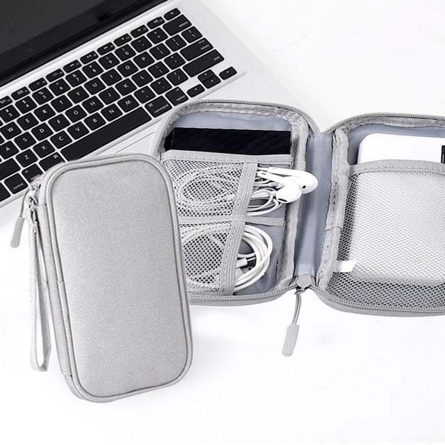 Vaidha Sac de Rangement pour Accessoires Numériques Gris, Doté d'Un design à Plusieurs Couches avec Compartiments Protecteurs pour Organiser les Alimentations, Disques Durs, Clés USB, Écouteurs et Câbles de Données. le Sac Comprend des Poches en Maille, un design sandwich pour une protection Accrue et une Fermeture Éclair Métallique Lisse. Fait de 100 % polyester, Il Est Léger, Anti-Poussière et compact, Mesure 19x11x3,5 cm. Montré Ouvert avec des Accessoires Organisés à Côté d'Un Ordinateur Portable.