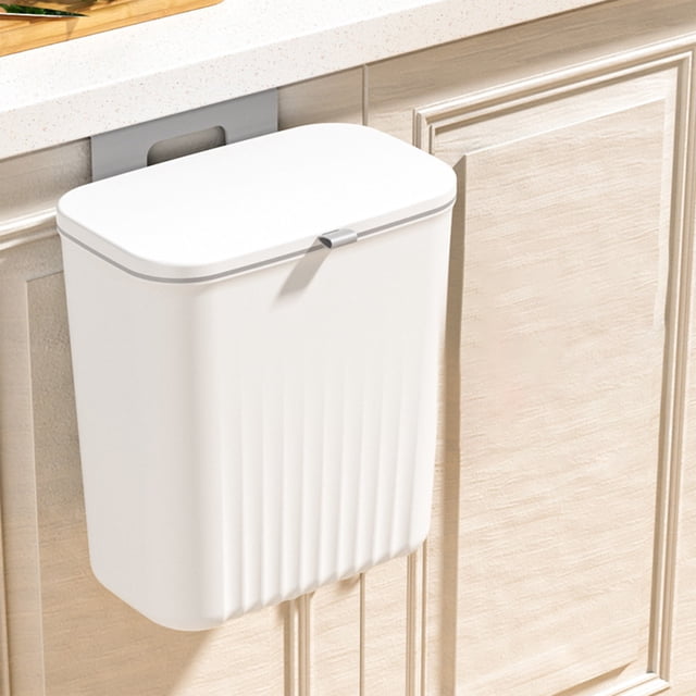LSLJS Hanging Trash Can with Lid in white, designed for kitchen cabinet doors. The trash can features a compact design with a sealing lid to reduce odors and can be hung on cabinet doors or walls. Made of durable polypropylene, it measures 29x26x16.5cm and is suitable for kitchens, bathrooms, RVs, and other spaces. The image shows the trash can securely mounted on a cabinet door under a countertop.