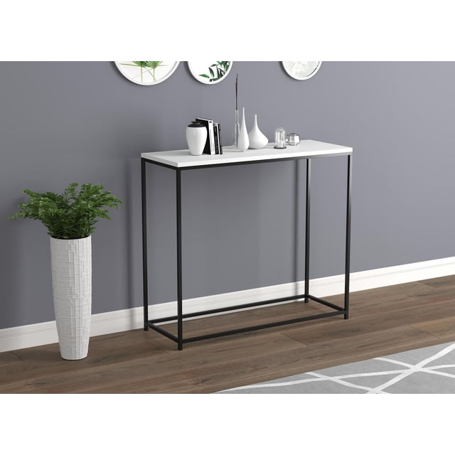 Safdie & Co. Table Console Blanche avec Base en Métal Noir avec Dessus Rectangulaire Blanc et Base de Cadre en Métal Noir, Exposée contre un Mur Gris et un Plancher de Bois. Décorée de vases Blancs, de Livres et d'Accentures en Verre, Elle Mesure 29 Pouces H x 32 Pouces L x 12 Pouces L. Cette Table Console Moderne Convient aux Entrées et aux Salons et Est Souvent Utilisée pour Exposer des Décorations Ou Organiser des Essentiels.
