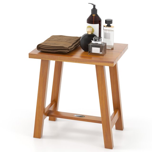 Gymax Teak Shower Bench Bathroom Shower Stool for Shaving Legs & Spa Bath Natural. Made of durable teak wood with a water-based finish, this bench features a smooth, splinter-free surface and solid legs supporting up to 350 lbs. The compact design includes reinforced bars and anti-slip foot pads for stability. Shown with bath items on top, it measures 16.5'' x 12'' x 18'' and is suitable for use as a shower bench, side table, or plant stand.