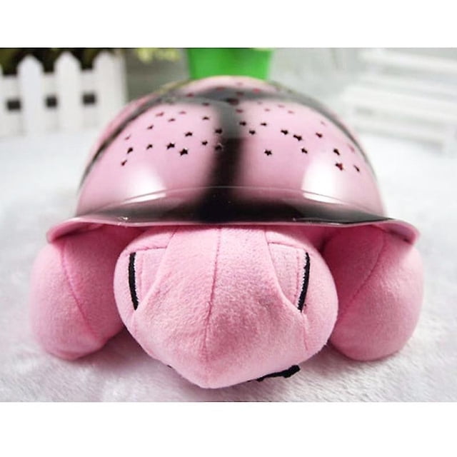 Veilleuse à DEL au Design de Tortue Mignonne - Projecteur d'Étoiles Mettant en Vedette une Tortue en Peluche Rose avec une Coquille en Plastique Noire Perforée de Formes d'Étoiles et de Lune. la Lumière Projette des Motifs Colorés sur les Murs et les Plafonds, Créant une ambiance Magique. Convient aux Enfants et aux Adultes, Elle Fonctionne avec 3 Piles AAA (Non Incluses) et Est Fabriquée en Plastique et Coton PP. Idéale comme Veilleuse pour Bébé Ou comme Cadeau Attentionné pour des occasions comme Noël Ou la Saint-Valentin.