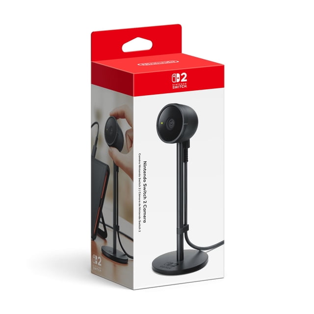 Nintendo Switch™ 2 Camera in black with a round lens on a slim vertical stand and circular base featuring the Nintendo Switch 2 logo, shown on retail packaging with a hand adjusting the camera connected to a Nintendo Switch 2 console via USB-C port, ideal for video chats using GameChat.
