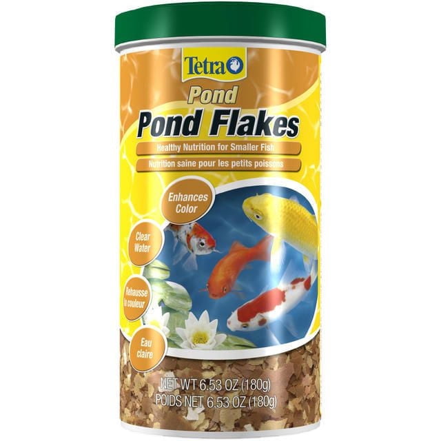 Tetra Pond Fish Food Flakes for Smaller Fish in a 6.53 oz (180g) container with a green lid, featuring a yellow and orange label with images of koi and goldfish, promoting healthy nutrition that enhances color and keeps pond water clear.