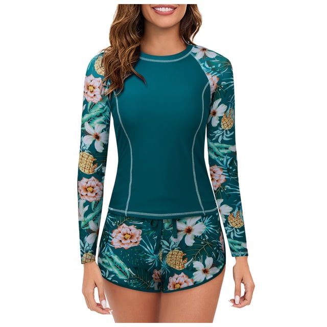 Kcodviy Women 2 Piece Long Sleeve Rash Guard with built-in bra swimsuits, featuring a teal crew neck swim shirt with floral-patterned long sleeves and matching boyshort bottoms. The UPF 50+ protective fabric is breathable, quick-drying, and stretch-lightweight, ideal for surfing, swimming, and other water sports.