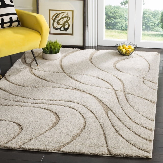 SAFAVIEH Florida Tapis Shag Abstrait Tamzen Présentant une Peluche crème Ton sur Ton à Ourlet Haut-Bas avec des Motifs de Vignes Damassées Tourbillonnantes Abstraites, Posé sur des Planchers de Bois Franc Sombres Près d'Un Fauteuil Jaune, une Oeuvre Abstraite Encadrée et un Bol Décoratif de Citrons, Idéal pour Ajouter Douceur et texture aux Salons.