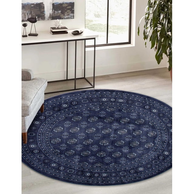 Tekke Oriental Area Rug for Living Room, Dining Room, Bedroom with a round shape featuring traditional symmetrical oval and diamond motifs in dark blue, placed on light hardwood flooring beside a gray sofa and white console table near a window, offering soft pile and classic style, also suitable as a decorative accent rug in various home spaces.