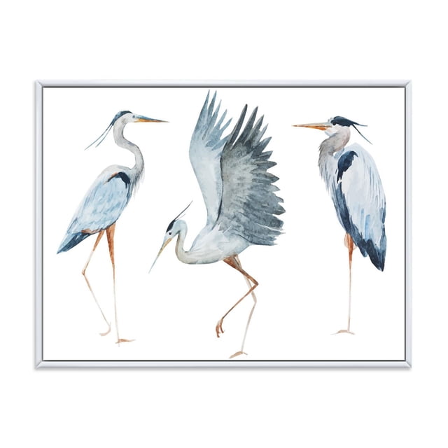 Designart Heron Birds II FLOAT FRAME WALL ART depicting three blue heron birds in different poses on white premium cotton canvas, printed with fade-resistant inks, gallery-wrapped over a 1-inch wood floating frame, ready to hang with included hardware, ideal for home décor.