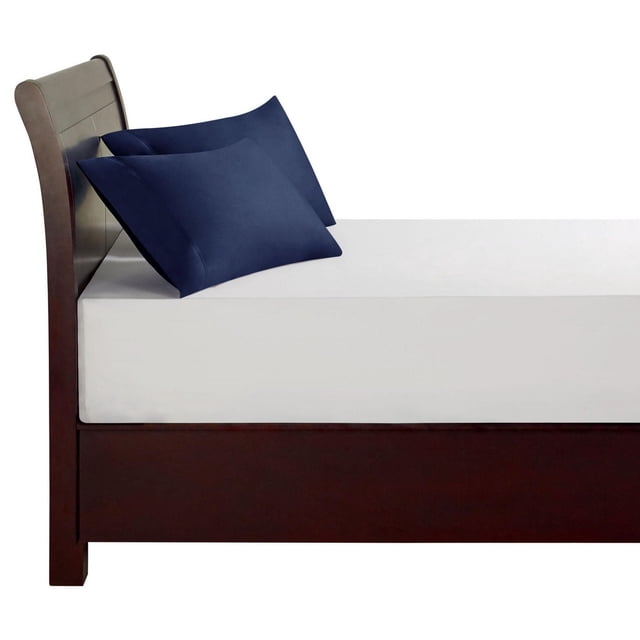 hometrends 100% Cotton Pillowcases in navy blue on a dark wood bed frame with headboard, showing two standard pillowcases made from breathable, lightweight 300 thread count cotton with a crisp percale weave and envelope closure, suitable for enhancing bedroom décor and comfort.