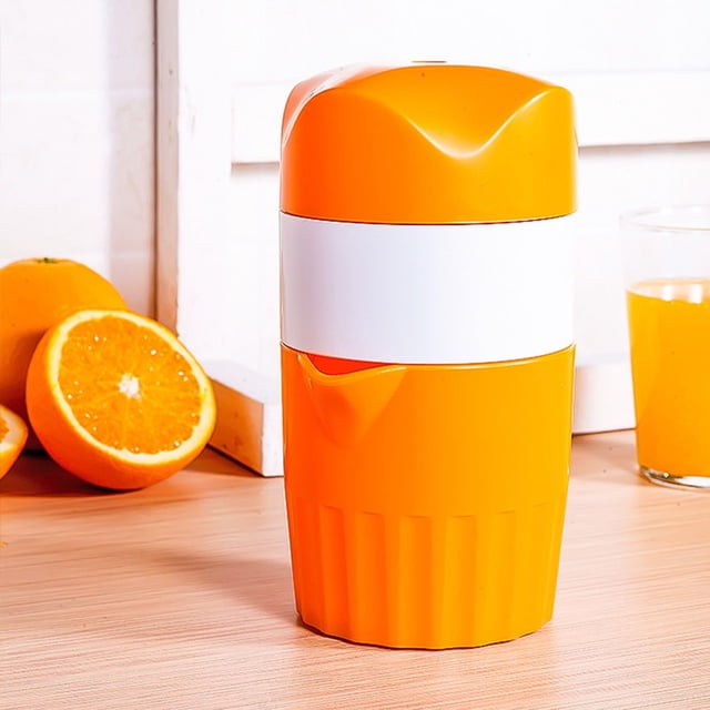 TopLLC Manual Fruit Juicer Lemon Press Fruit Squeezer Juice Extractor Machine Orange Juicer in a vibrant orange and white design. The compact juicer features an ergonomic rotary handle and a pour spout for easy, mess-free juice extraction. It is made of food-grade PP material and has a 16 oz (2-cup) capacity, suitable for juicing oranges, lemons, tangerines, and grapefruits. The juicer is displayed on a wooden countertop with fresh oranges and a glass of orange juice in the background.