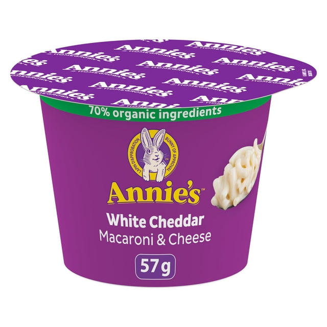 Annie's Homegrown Macaroni & Cheese White Cheddar microwavable 57 g cup with purple packaging and green 70% organic ingredients banner, showing creamy white cheddar pasta on a spoon, suitable for quick and convenient pasta side dishes.