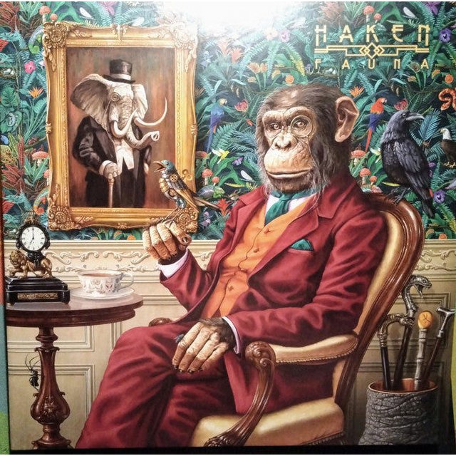 HAKEN FAUNA (GATEFOLD BLACK 2LP & LP BOOKLET) album cover featuring a surreal illustration of a chimpanzee in a red suit seated in an ornate chair, holding a bird. The background includes a vibrant floral wallpaper, a framed portrait of an elephant in formal attire, and various decorative elements like a clock and a tea set. The album title and band name are displayed in the upper right corner.